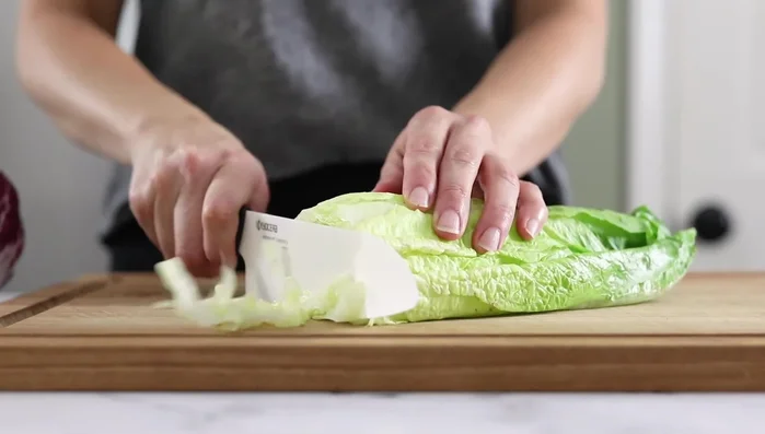 Chop romaine lettuce into bite-sized pieces. Chop radicchio (optional). Slice cherry tomatoes in half. Thinly slice red onion and chop pepperoncinis. (139.5)