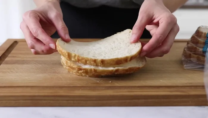 Preheat oven to 350°F (28.56). Cut bread into 1/2-inch cubes. Toss with olive oil, garlic powder, oregano, and salt.