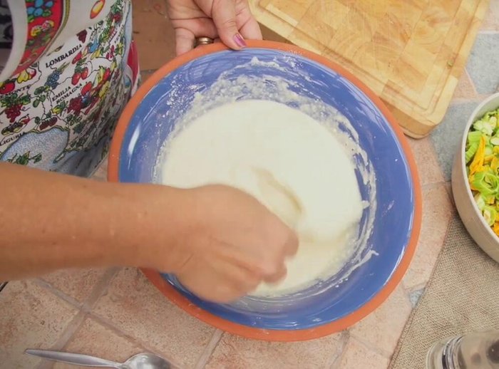 Stir in the chopped zucchini flowers, basil, and the remaining flour, ensuring a thick consistency.