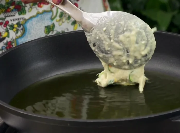 Drop spoonfuls of the batter into the hot oil, ensuring the oil is hot enough to prevent sogginess.