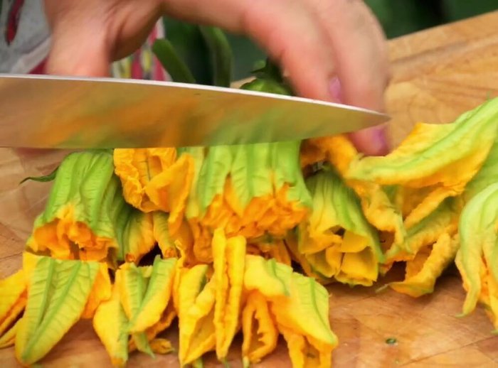 Roughly chop the zucchini flowers and stalks. Keep the flowers with a small zucchini attached separate from those without.