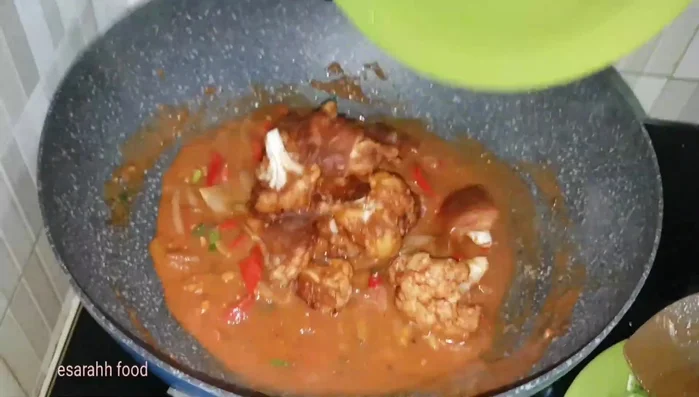 Add the golden brown cauliflower to the sauce, sprinkle with spring onions, and stir quickly.