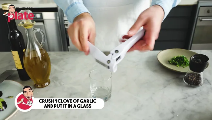 Crush one garlic clove in a glass bowl.