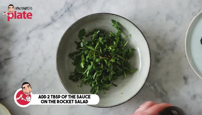 Dress the rocket salad with a small amount of the garlic-balsamic-oil mixture.