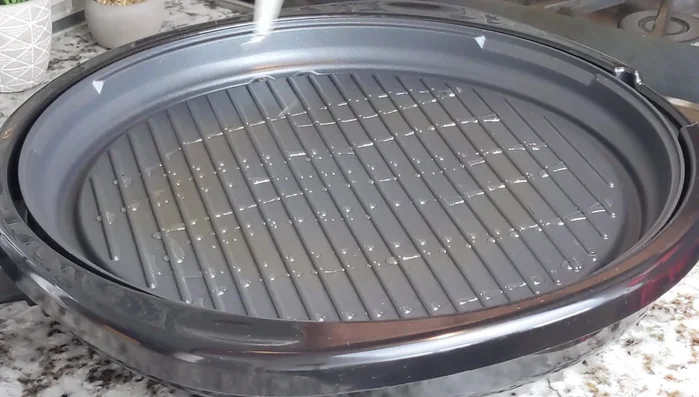 Place the marinated shrimp on the hot grill, spreading them out evenly.