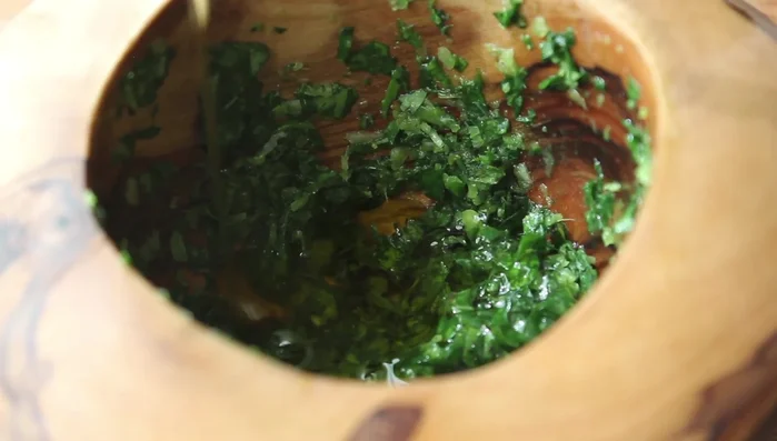 Drizzle in olive oil, a little at a time, mixing and crushing until you reach desired consistency.