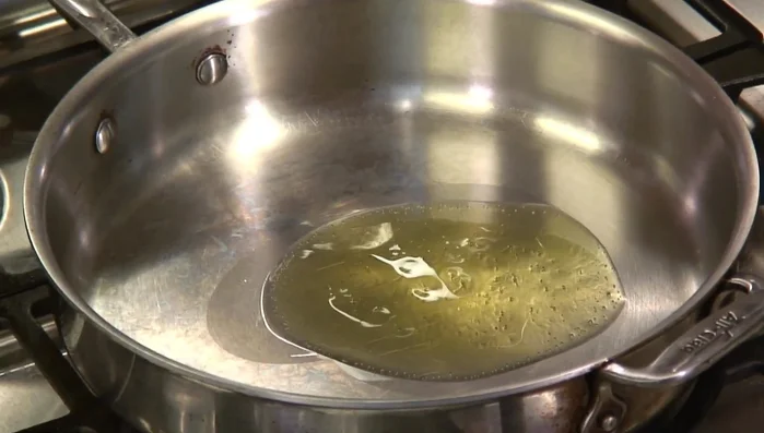 Prepare the sauce: Heat olive oil in a saute pan. Add sliced garlic and cook until lightly browned.