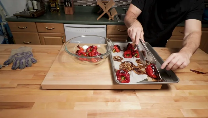 Place the roasted peppers in a large bowl, cover tightly with plastic wrap, and let them steam to loosen the skin.