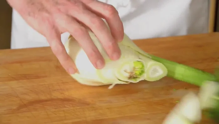 Cut the fennel, leaving some of the root stem attached to each piece to keep the leaves intact during grilling and roasting. (Cut right down the center)