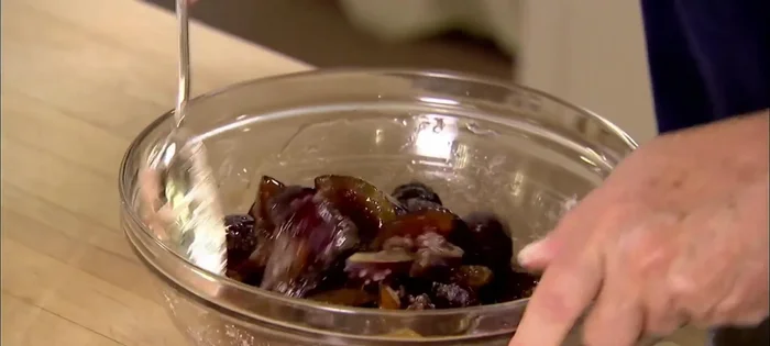 Arrange the macerated plums tightly in the crust, creating a pretty pattern.