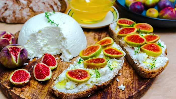 Once the bread is slightly cooled, spread a generous layer of whipped ricotta onto each slice.