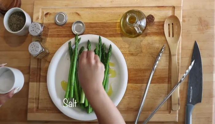 Drizzle olive oil on asparagus and season with salt, pepper, red chili flakes, and lemon pepper seasoning.