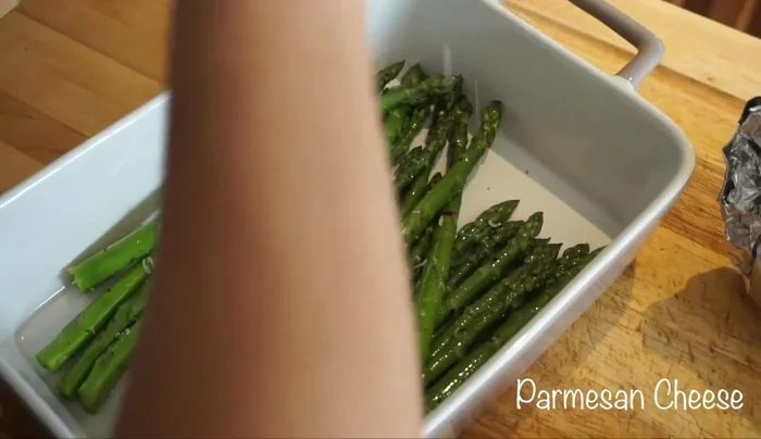 Add fresh parmesan cheese to the grilled asparagus.