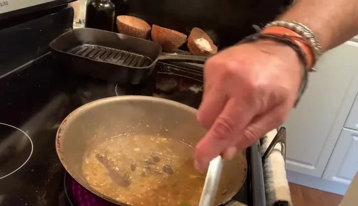 Add fish stock to the sauce and continue to simmer until it thickens.