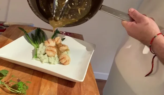 Pour the sauce over the scallops and risotto.