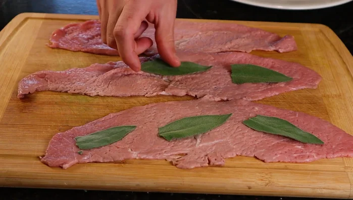 Place three pieces of fresh sage on each slice of veal. (119.36)