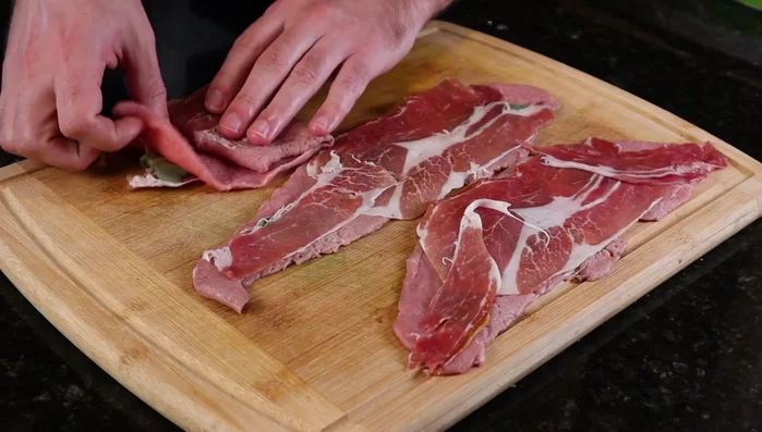 Fold the veal, sage, and prosciutto into a little pocket. (153.72)