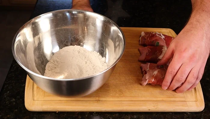Dredge the veal packets in seasoned flour (salt and pepper). (199.08)