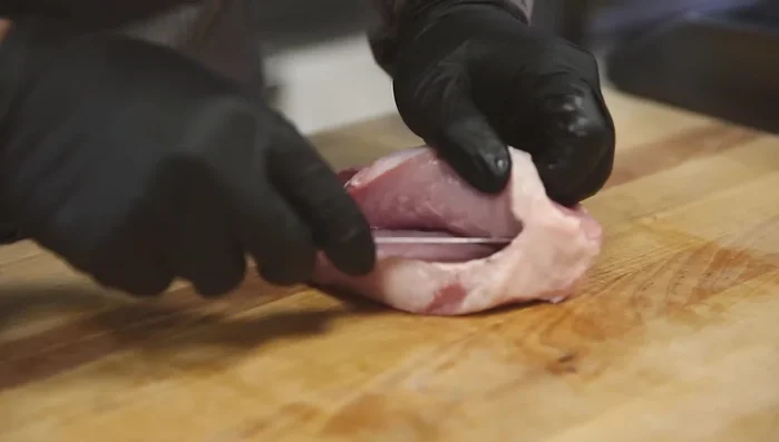 Stuff the pork chop with the prosciutto filling, pressing firmly to secure it inside. Use a skewer to secure the chop.