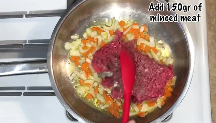 Add the minced meat (beef or plant-based alternative) to the pan. The original recipe uses three meats (chicken, pork, beef).
