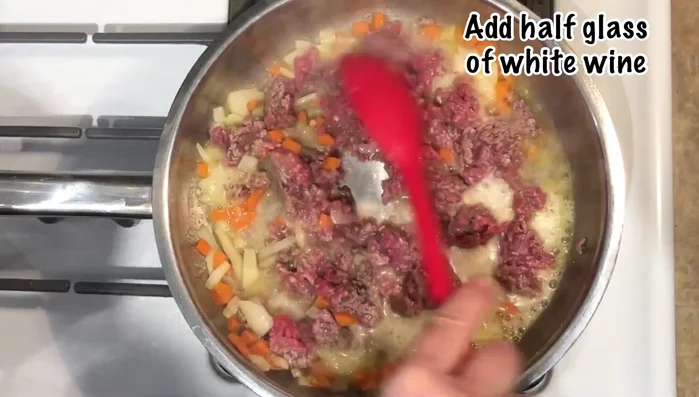 Add half a glass of wine or beer to the pan. Stir and cook until the meat is fully cooked.