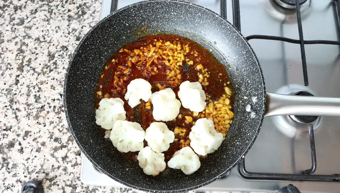 Add the cooked cauliflower florets to the pan. Season with salt and pepper. Gently mix until the cauliflower is coated in the garlic and paprika sauce. (292.96)