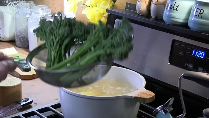 Two to three minutes before the pasta is done, add broccolini to the pot on a colander to steam.