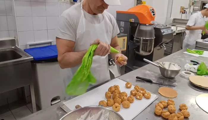 Cut the profiteroles in half. You can do this by hand or with a machine.