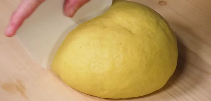 Tear off a piece of dough, lightly sprinkle it with flour, and flatten it out.