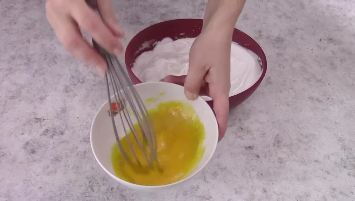 Beat the yolks slightly and gently fold into the egg whites. Add oil, flour, and vanilla, mixing delicately.
