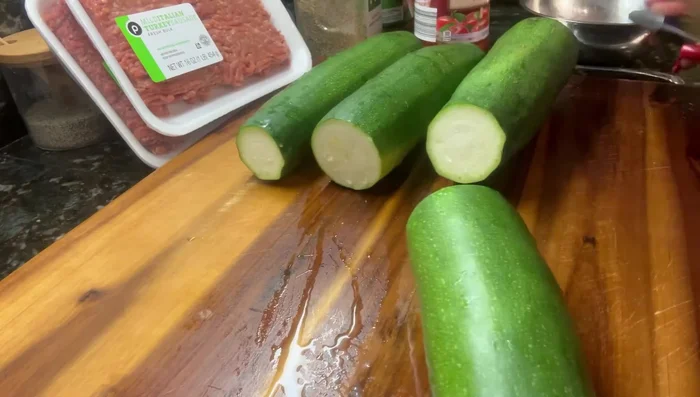 Cut the ends off the zucchini and discard them. Then, carefully scoop out the seedy part of the zucchini, creating a boat shape. Be careful not to puncture the bottom.