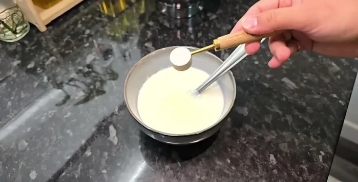 In a separate bowl, mix room temperature curd, sugar, baking powder, and baking soda. The mixture will become bubbly.