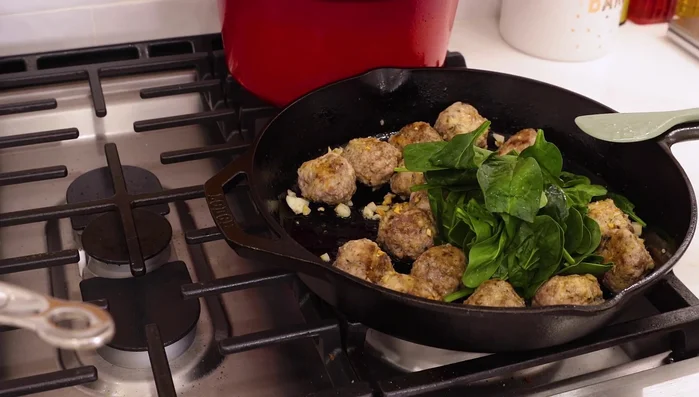 Once the meatballs are heated through, add spinach to the skillet. Stir until wilted.