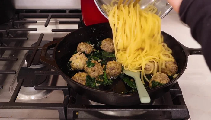 Add the cooked pasta to the skillet with the meatballs and spinach.