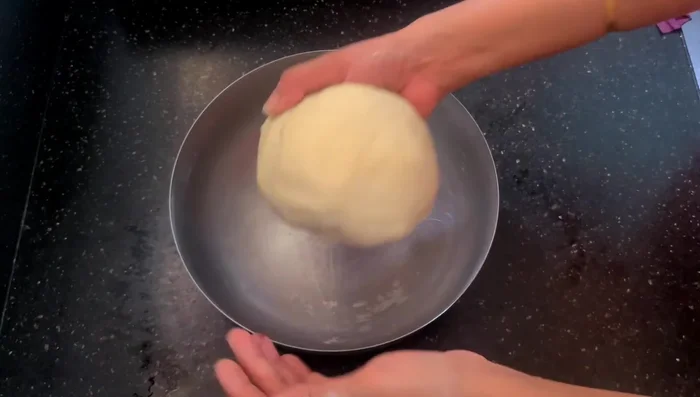 Shape the dough into a ball, coat it with oil, and place it in a bowl.