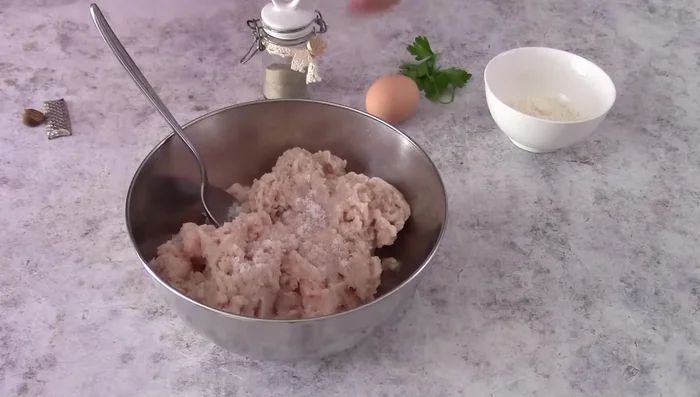 Season the minced chicken with salt, pepper, nutmeg, an egg, parmesan cheese, and parsley. Mix well.