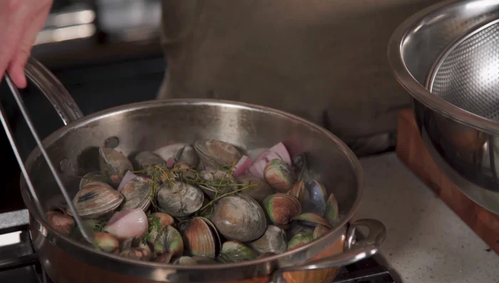Remove clams that don't open; discard them. Reserve some of the juicier clams in their shells for plating.