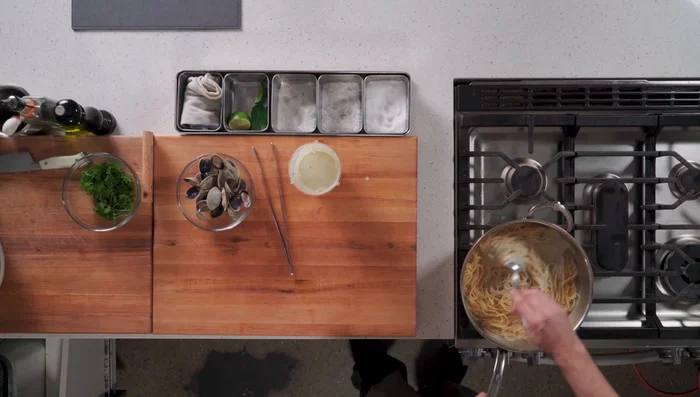 Add the cooked spaghetti to the clam sauce.