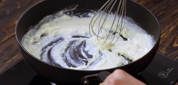 Gradually add the boiled and cooled milk, whisking constantly to avoid lumps, until you have a creamy white sauce.