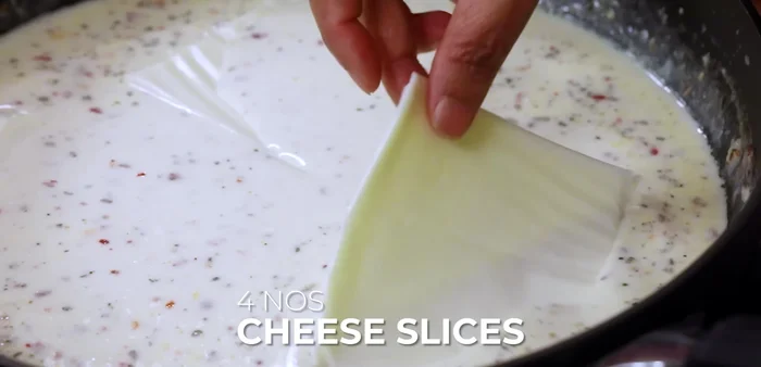 Add cheese slices to the sauce and let it melt gently.