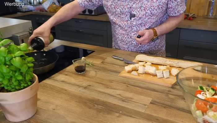 Heat olive oil in a pan. Add rosemary and one clove of garlic. Add the bread cubes and toast until golden brown and crispy.