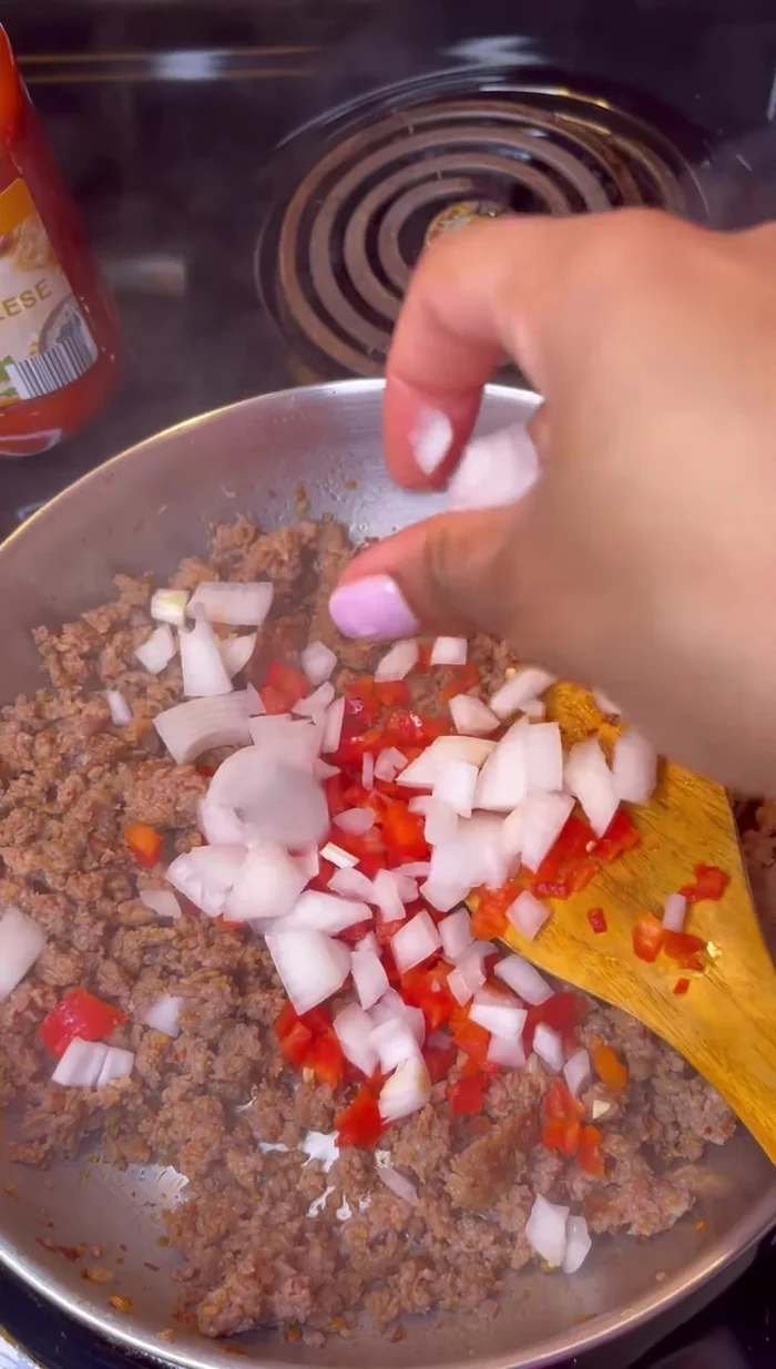 Add peppers, onions, and seasonings (Slap Your Mama, Italian seasoning, garlic powder, onion powder, crushed red pepper, and fennel seeds). Sauté.