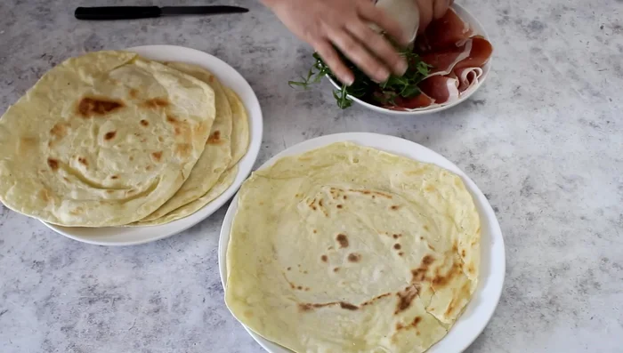 Stuff the cooked Crescia with your choice of filling (e.g., spreadable cheese, cold cuts, and salad).