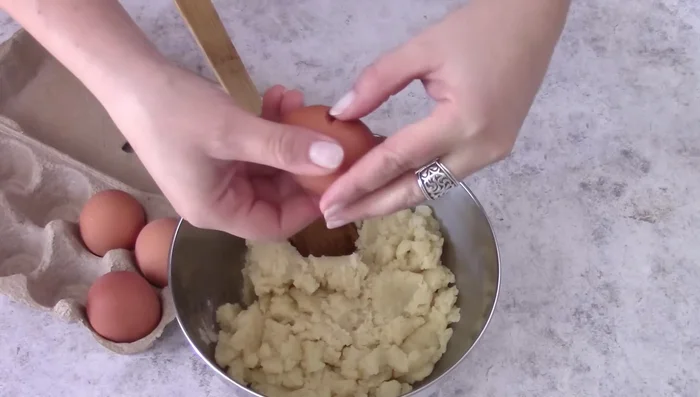Add eggs to the cooled zeppolone base, one at a time.