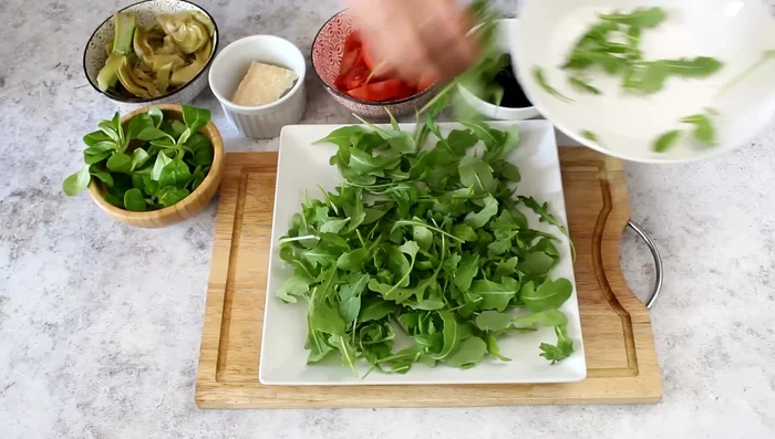 Prepare the artichoke salad: Layer rocket, sun-dried tomatoes, red tomato wedges, artichokes, olives, parmesan, and hard-boiled egg wedges.