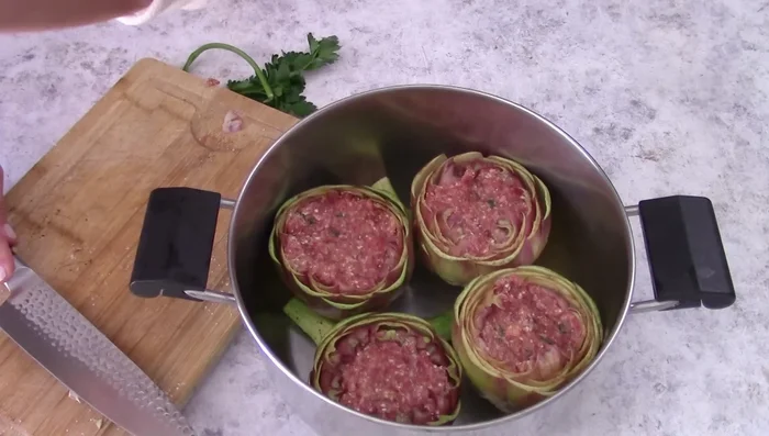 Cook the stuffed artichokes in a pot with garlic, parsley, oil, white wine, and water for about an hour, basting occasionally.