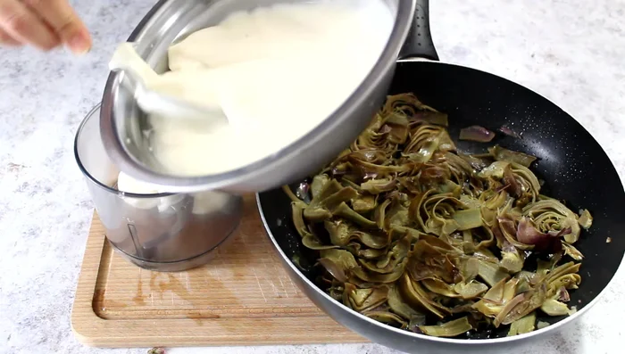 Mix half of the cooked artichokes with half of the béchamel sauce in a mixer until blended.