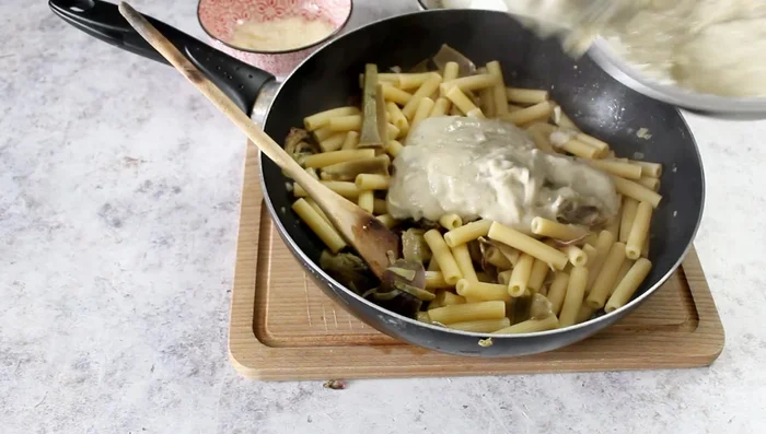 Add the artichoke cream to the cooked pasta.