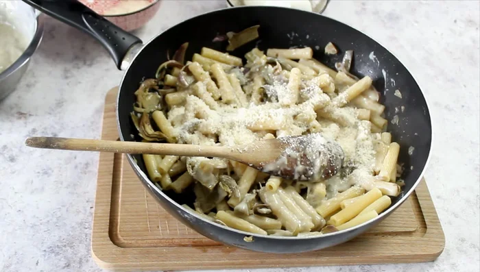 Mix half of the parmesan cheese and torn mozzarella into the pasta.