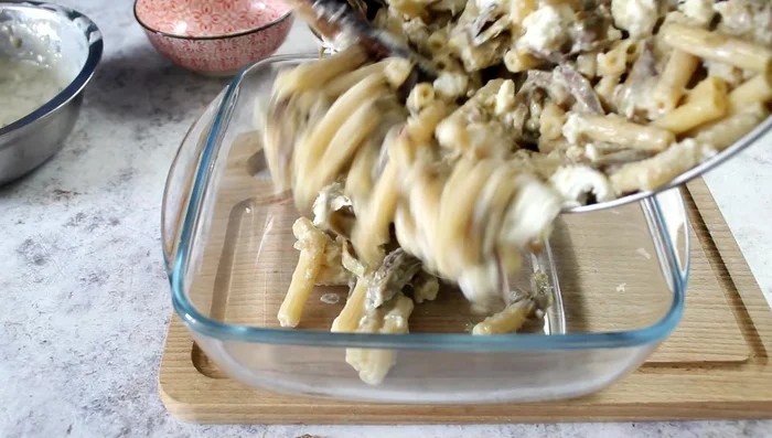 Transfer the pasta mixture to a baking dish. Top with the remaining béchamel sauce, parmesan cheese, and mozzarella.